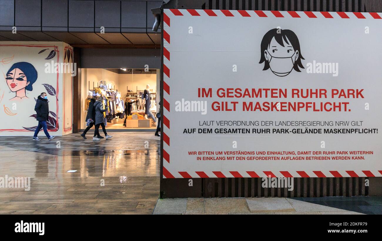 Ruhrpark Shopping Centre, Bochum, Germany, 15th Dec 2020. Large signs remind shoppers of mandatory mask wearing. The normally bustling shopping centre appears quiet on the last day before the so called 'hard lockdown' in Germany. Today was the last day retailers and services, apart from food and essential supplies, were allowed to be open before the lockdown starts tomorrow. It also includes the closure of most secondary schools, hairdressers and related services. Further measures are taken on a state by state basis.Credit: Imageplotter/Alamy Live News Stock Photo