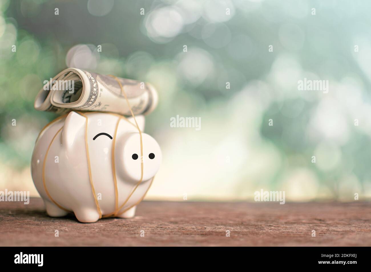 Close-up Of Paper Currency And Piggy Bank On Table Stock Photo