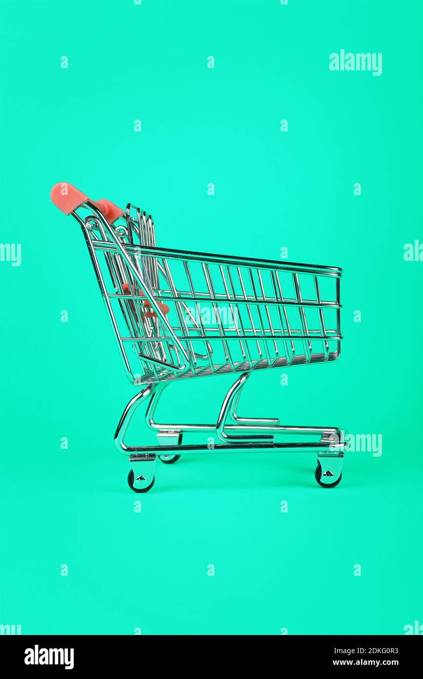 Empty Shopping Cart Against Green Background Stock Photo