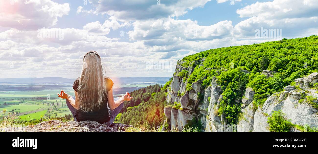 Woman meditates in a mountain landscape Stock Photo