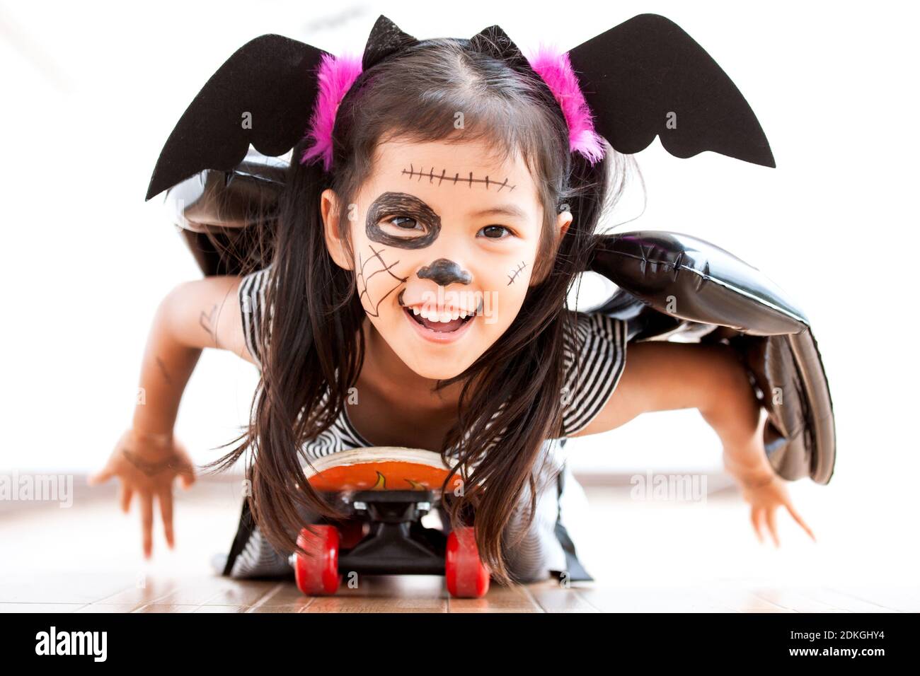Happy asian little child girl in costumes and makeup having fun to play  with roller board, She need to fly like a bat on Halloween celebration  Stock Photo - Alamy