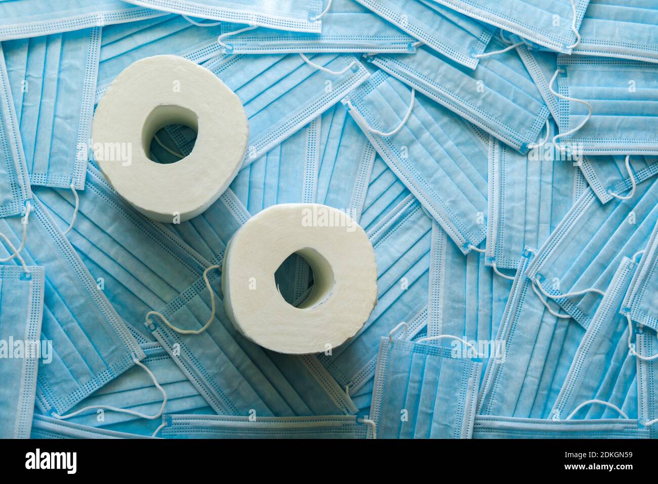 Background of a lot of medical masks and toilet paper. Concept of year 2020 and protection from flu and virus, coronavirus. Place for text. Stock Photo