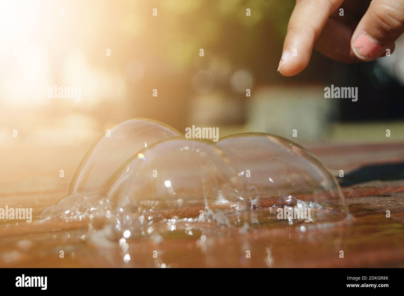 Close-up Of Hand Touching Bubble Stock Photo