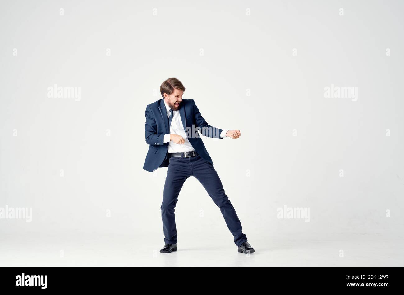 a man in a suit pulls a rope on a light background in full growth Stock ...