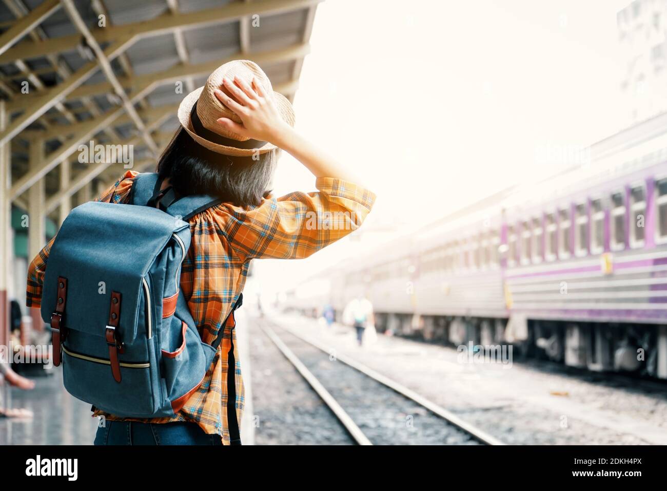 Rear View Of Woman Waiting For Train At Railroad Station Platform Stock Photo