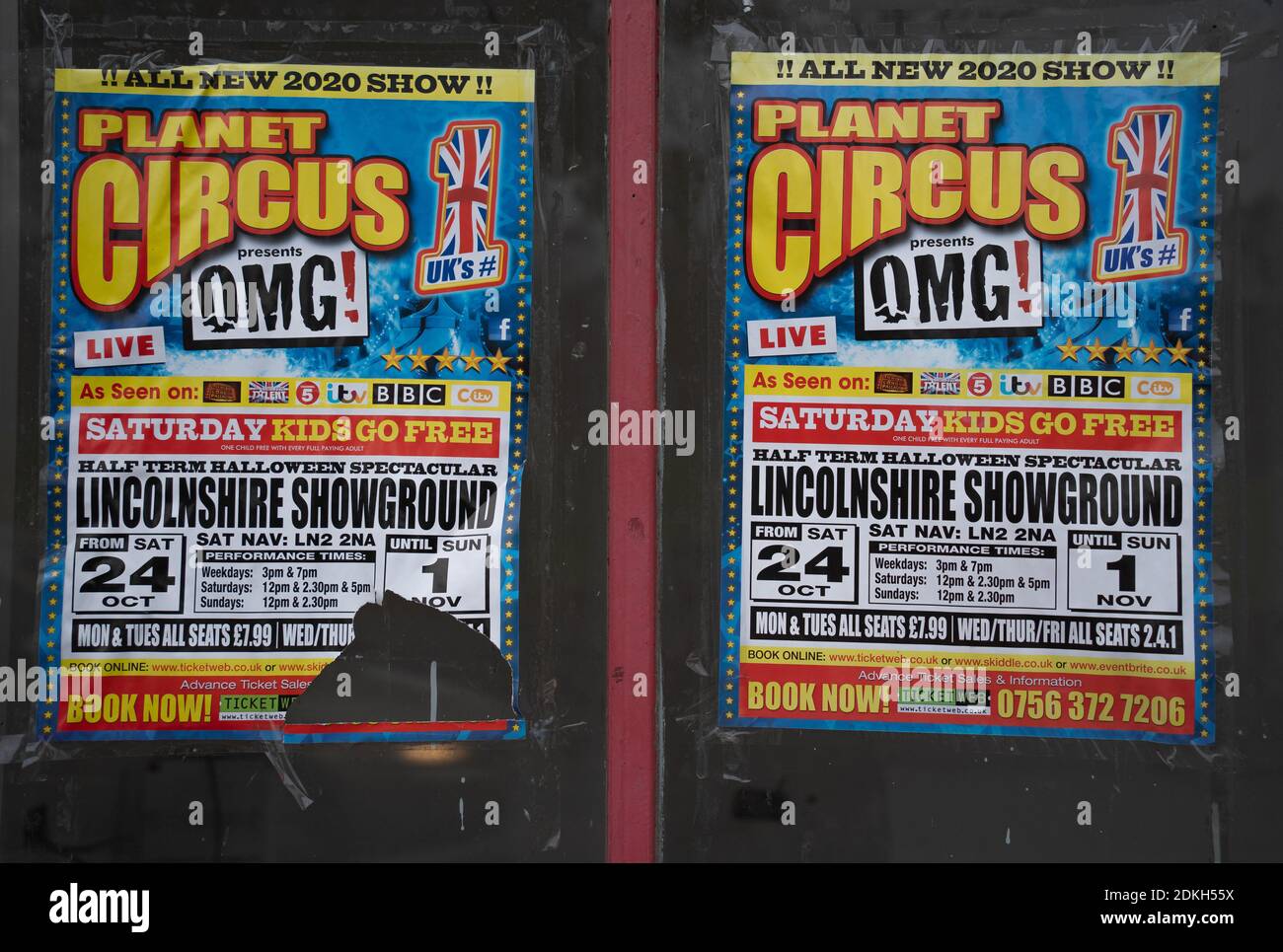 Circus advertising poster, empty shop window, pasted over windows, closed shop, derelict, vandalism, fly poster, nuisance, antisocial behaviour . Stock Photo