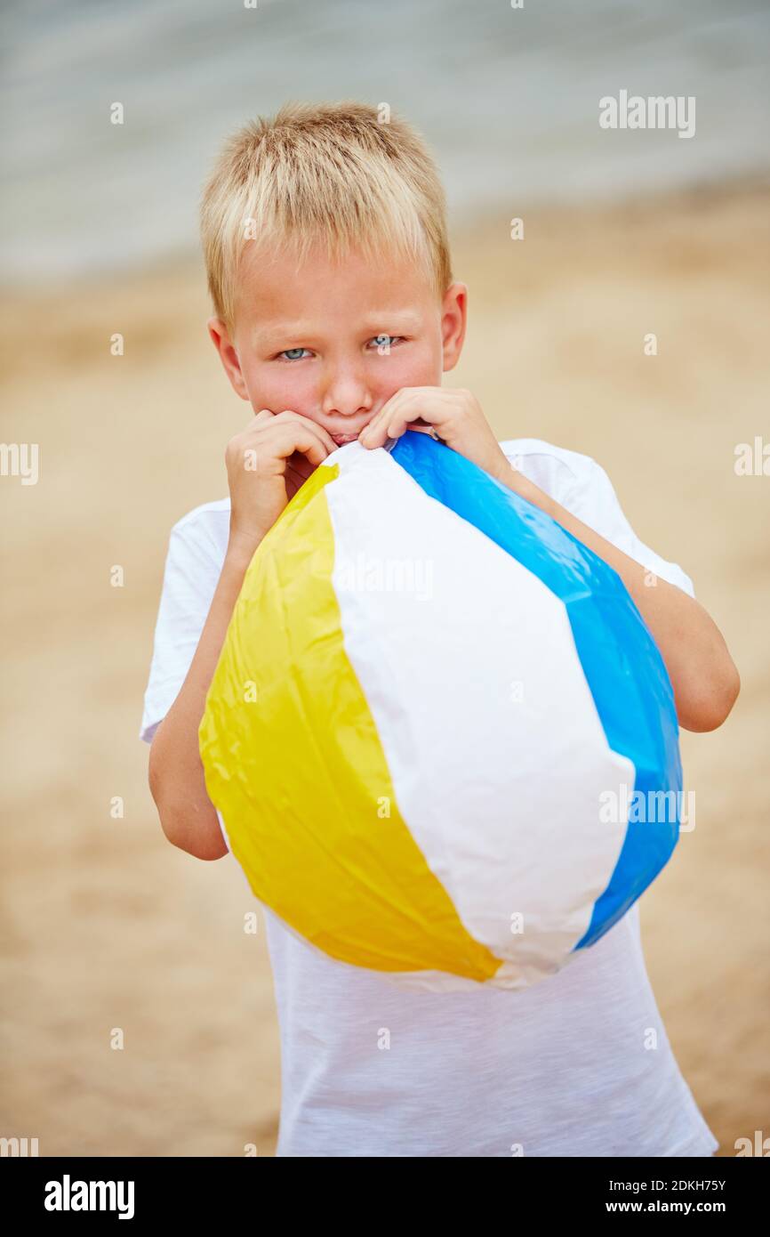 Boy in summer inflating a beach ball with his mouth Stock Photo Alamy