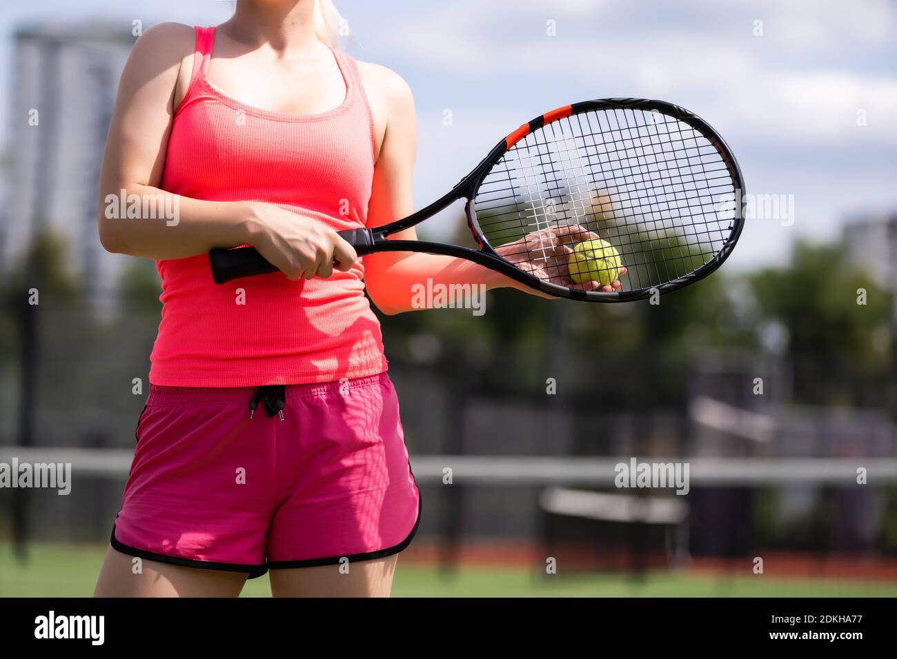Woman playing tennis holding a racket and smiling Stock Photo - Alamy