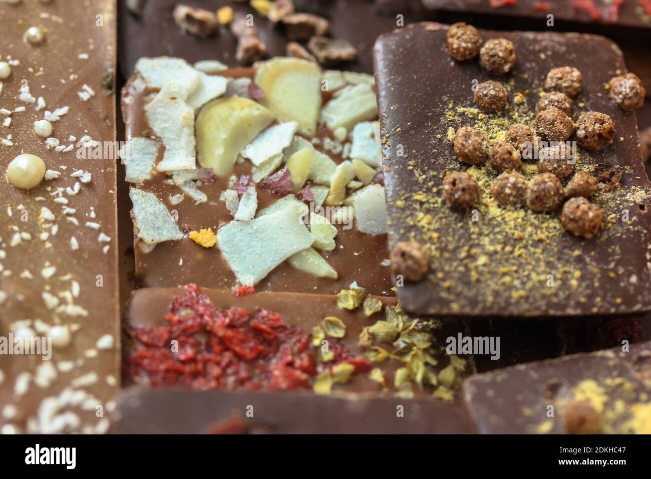Handmade milk and dark chocolate bars with nuts, herbs and flowers