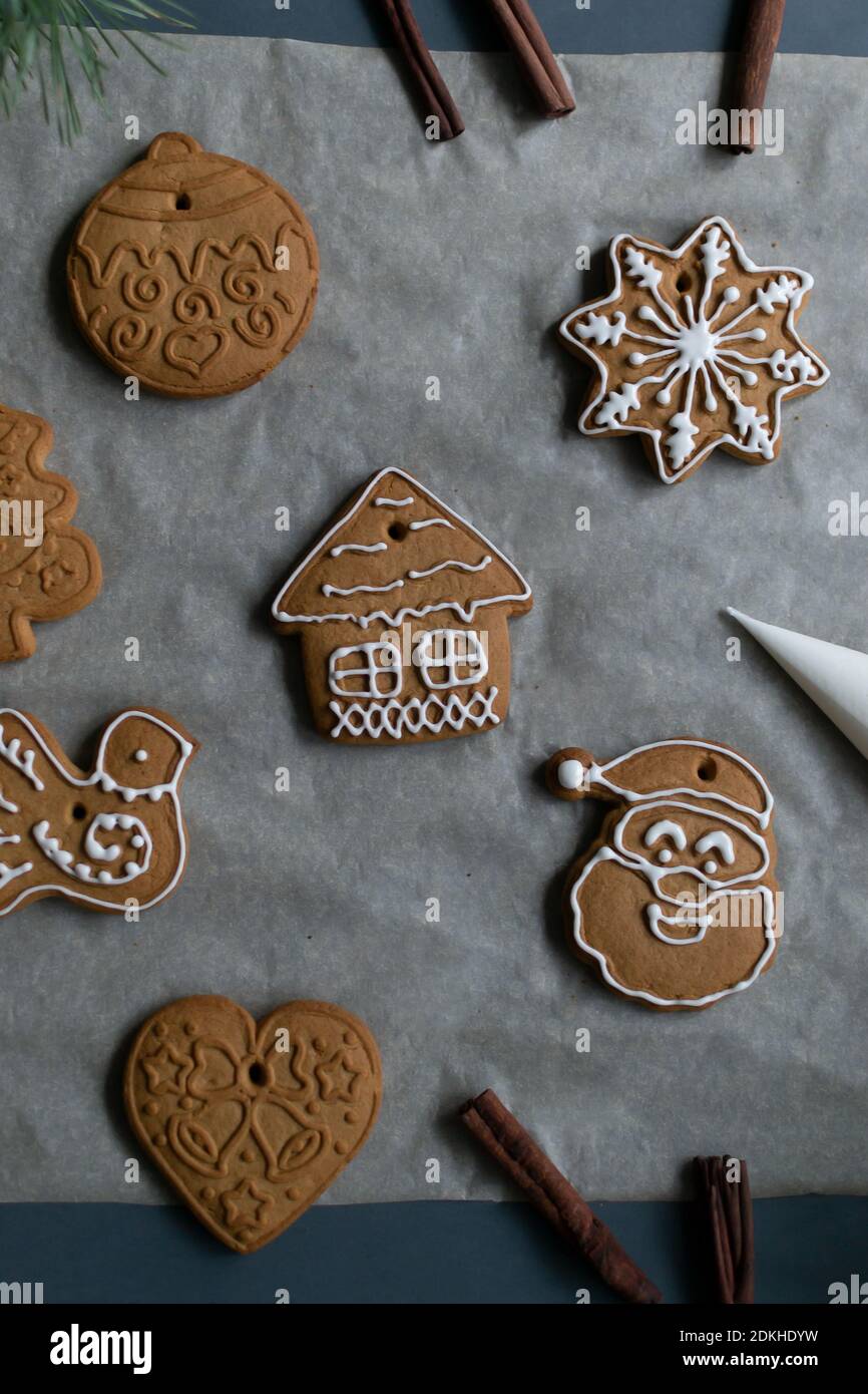 Gingerbread cookies on baking paper on a gray background. Homemade baking. Christmas holidays concept. Vertical orientation. Stock Photo