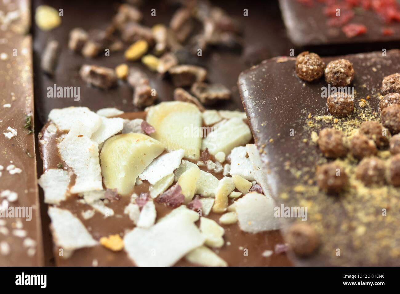 Handmade milk and dark chocolate bars with nuts, herbs and flowers