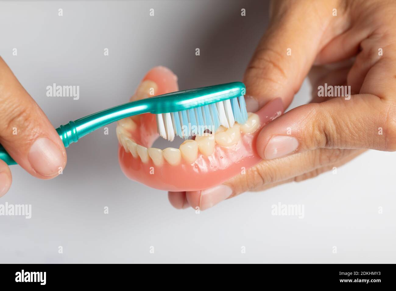 Doctor Dentist carefuly show how to Clean dental prosthesis with