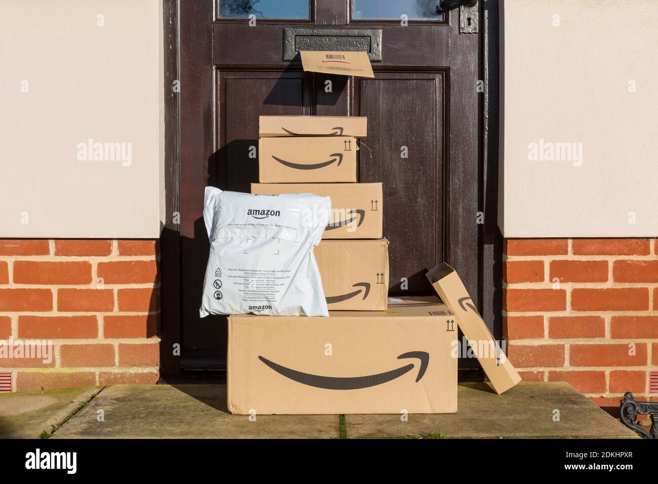 Internet shopping so an Amazon delivery of parcels, and boxes outside a front door. Stock Photo