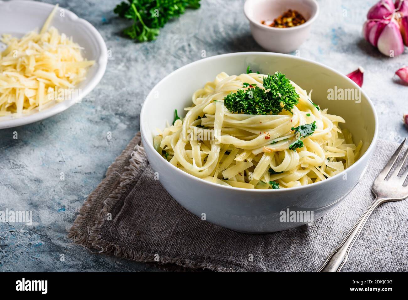 Easy lunch recipe. Linguine pasta with olive oil, garlic, fresh parsley and grated parmesan cheese. Stock Photo