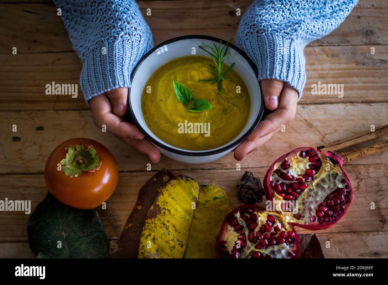 View of vegetable soup in autumn colors with hands holding dish with  vegetarian fresh food ready to eat and stay healthy - wooden table and  health lifestyle concept people Stock Photo - Alamy
