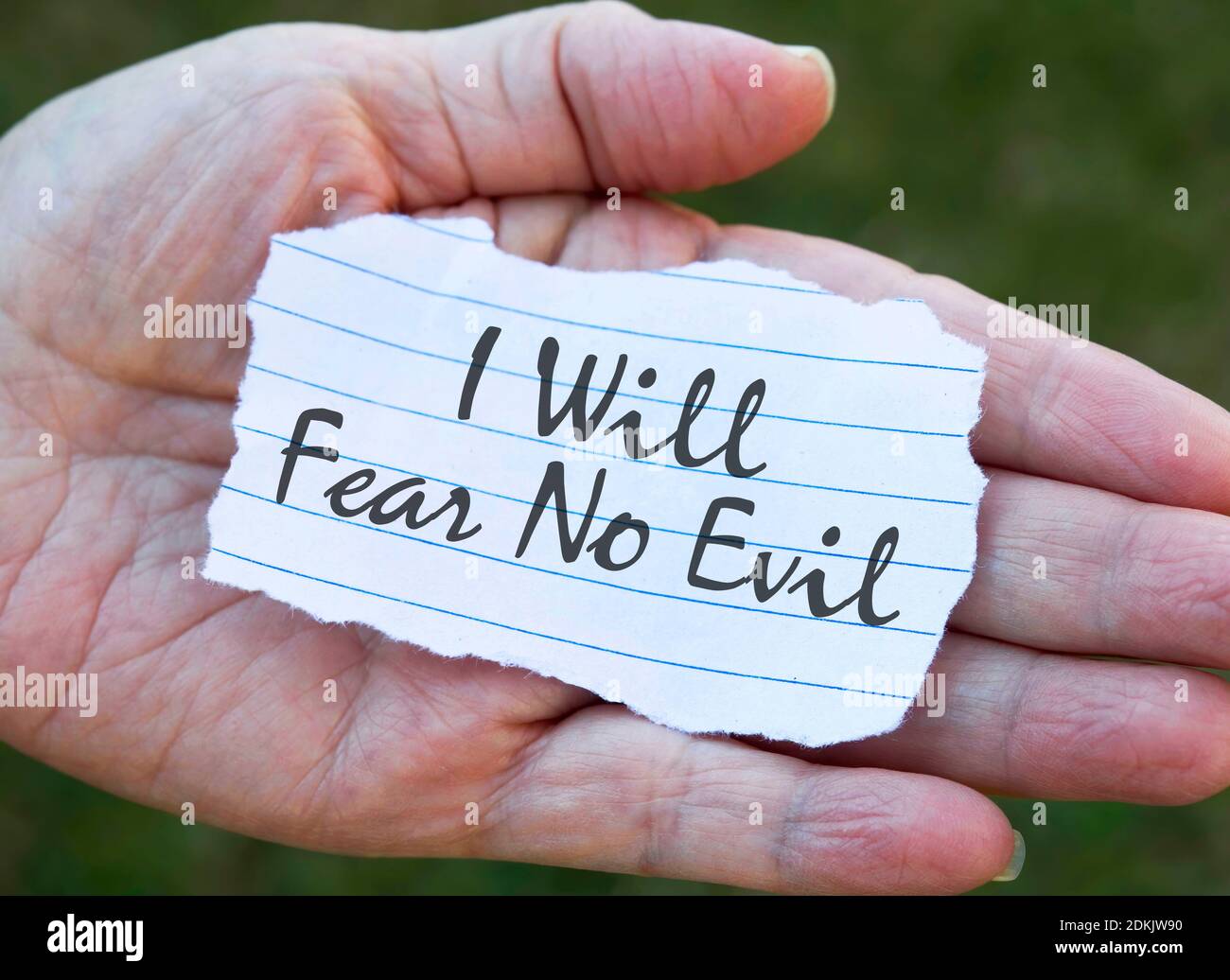 Paper note in hand, I will fear no evil. Stock Photo
