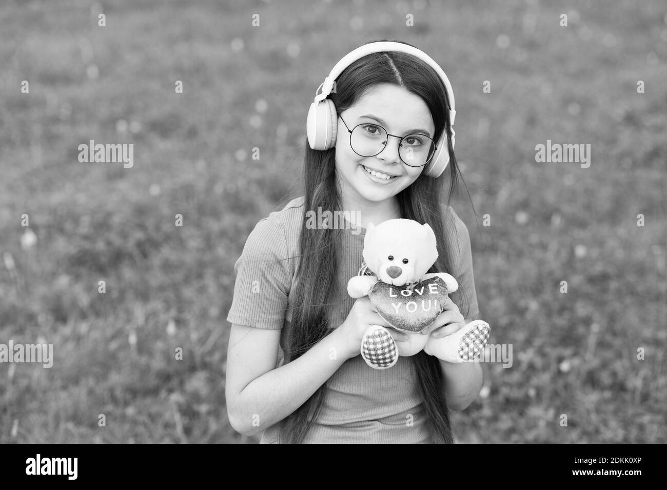 Love connection. Happy child hold teddy bear toy. Little girl play with toy outdoors. Toy store. Gift shop. Valentines present. Childhood game. Summer fun. Playtime. Adorable toy to fall in love with. Stock Photo