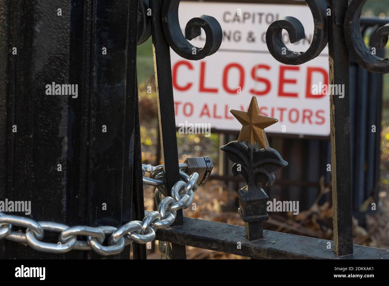 Austin, TX USA December 15, 2020: Sign reading 'Capitol Building and Grounds CLOSED to all visitors'  sits behind the locked gates of the Texas Capitol in Austin the evening before Texas Governor Greg Abbott ordered the grounds reopened to the public. The Capitol has been closed for months following vandalism to the grounds and building during protests against police violence after the murder of George Floyd in May, 2020. Credit: Bob Daemmrich/Alamy Live News Stock Photo