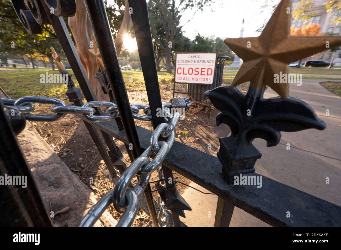 Austin, TX USA December 15, 2020: Sign reading 'Capitol Building and Grounds CLOSED to all visitors'  sits behind the locked gates of the Texas Capitol in Austin the evening before Texas Governor Greg Abbott ordered the grounds reopened to the public. The Capitol has been closed for months following vandalism to the grounds and building during protests against police violence after the murder of George Floyd in May, 2020. Credit: Bob Daemmrich/Alamy Live News Stock Photo