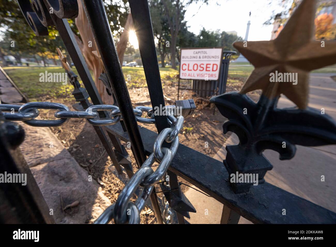 Austin, TX USA December 15, 2020: Sign reading 'Capitol Building and Grounds CLOSED to all visitors'  sits behind the locked gates of the Texas Capitol in Austin the evening before Texas Governor Greg Abbott ordered the grounds reopened to the public. The Capitol has been closed for months following vandalism to the grounds and building during protests against police violence after the murder of George Floyd in May, 2020. Credit: Bob Daemmrich/Alamy Live News Stock Photo