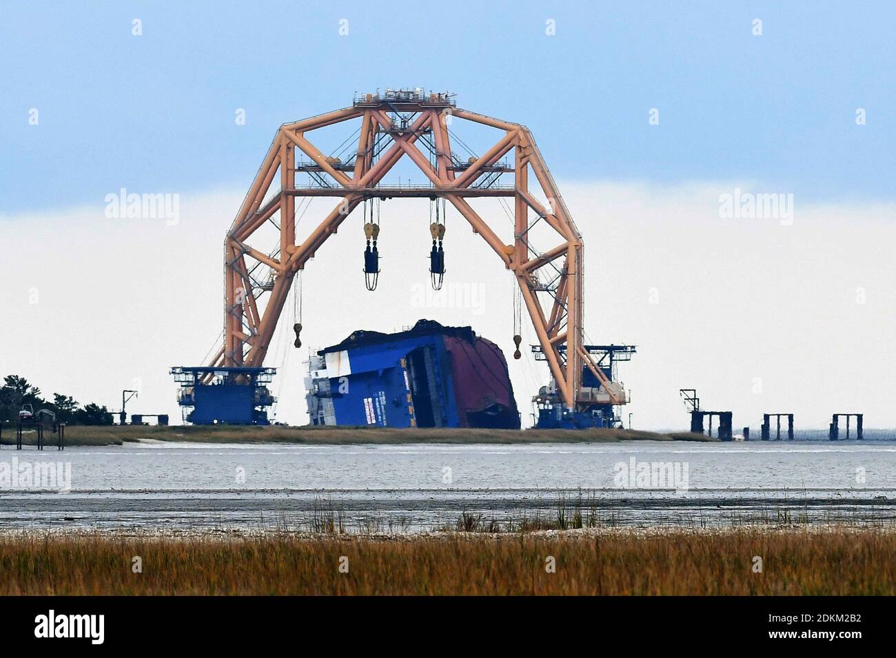 Georgia, USA. 14th Dec, 2020. December 14, 2020 - St. Simons Island, Georgia, United States - The Golden Ray cargo ship lies on its side under a  heavy-lift twin-gantry catamaran on December 14, 2020 in St. Simons Island, Georgia. A salvage company is cutting the vessel into eight segments, with the bow section having been cut and removed by a barge to be scrapped. The vehicle carrier, loaded with 4200 new cars, capsized in St. Simons Island Sound on September 8, 2019 as it was leaving the Port of Brunswick, Georgia. (Paul Hennessy/Alamy) Credit: Paul Hennessy/Alamy Live News Stock Photo