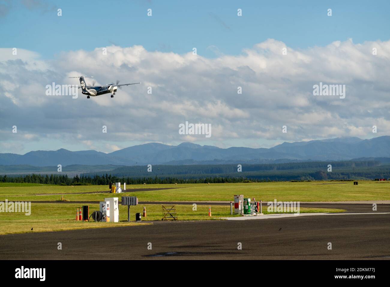 A Bombardier Dash 8 Q300 series painted in all black colors lifts off the runway in Taupo Airport, New Zealand Stock Photo