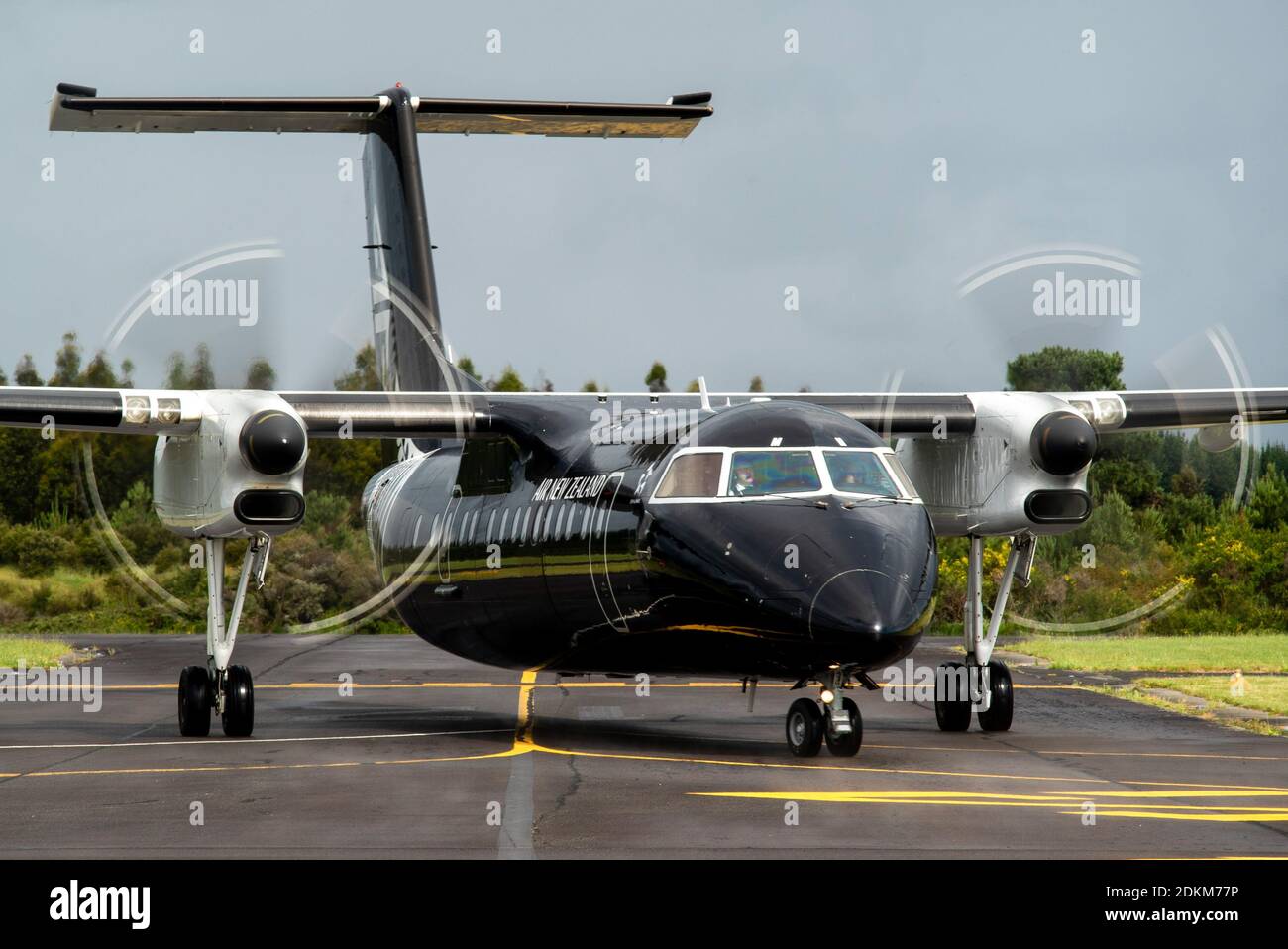 A Bombardier Dash 8 Q300 series of Air New Zealand painted in all black colors, taxis in for parking at Taupo Airport Stock Photo