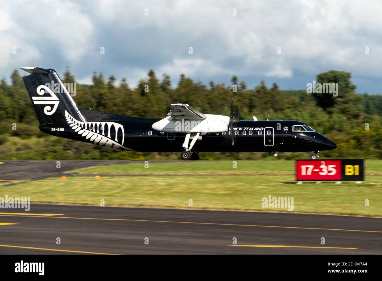 An Air New Zealand Bombardier Dash 8 Q300 series painted in all black colors accelerates for takeoff from Taupo Airport Stock Photo