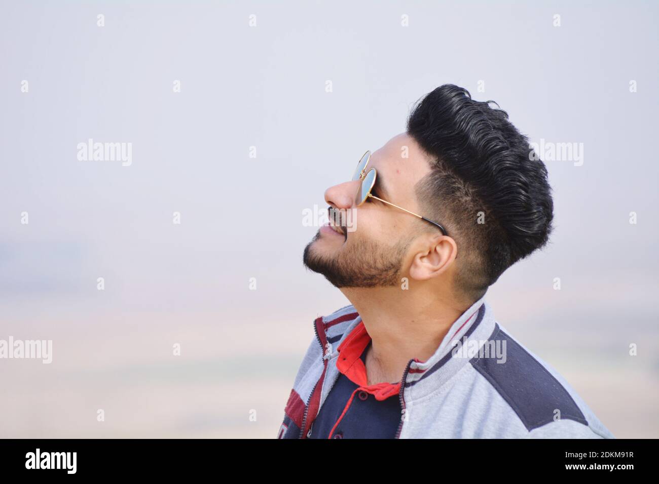 Side View Of Young Man Wearing Sunglasses Against Clear Sky Stock Photo -  Alamy