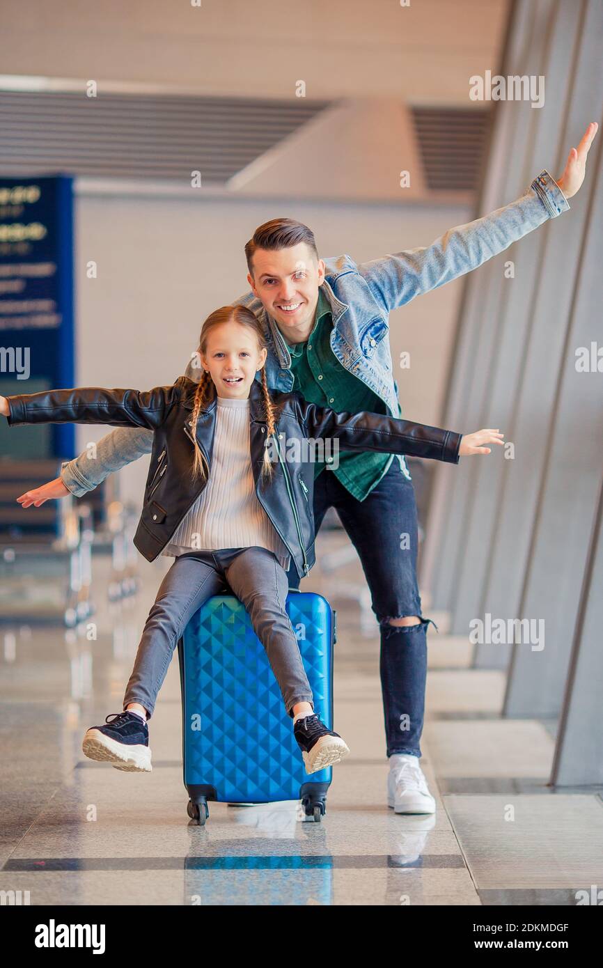 Portrait Of Happy Father And Daughter With Arms Outstretched At Airport