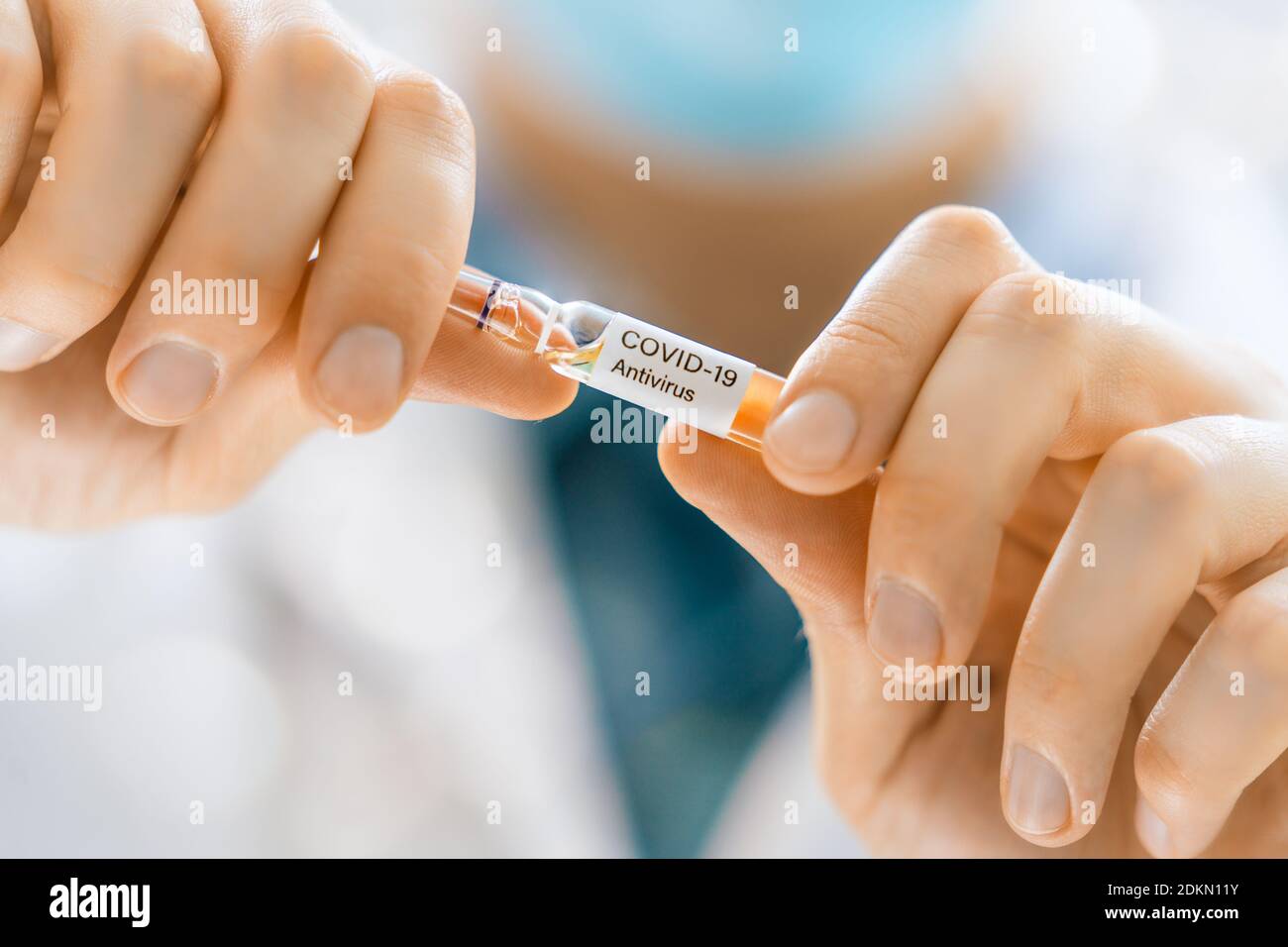 Medical doctor or laborant holding tube with anti Coronavirus vaccine. Concept of Covid-19 treatment and prevention. Stock Photo