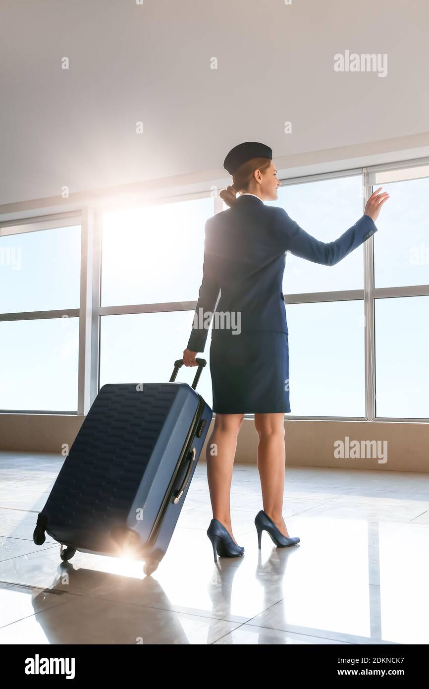 Young stewardess with luggage at the airport Stock Photo Alamy
