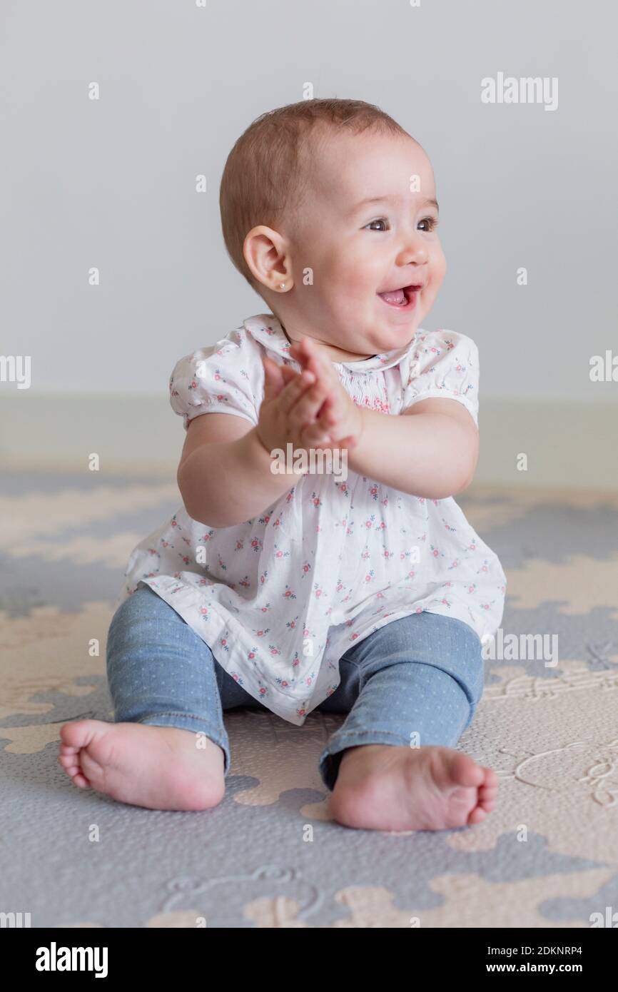 Cute Baby Girl Sitting On Mat Stock Photo - Alamy