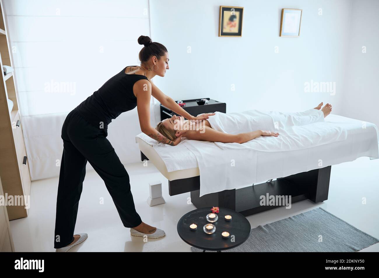 Woman doing massage on back of female customer Stock Photo - Alamy