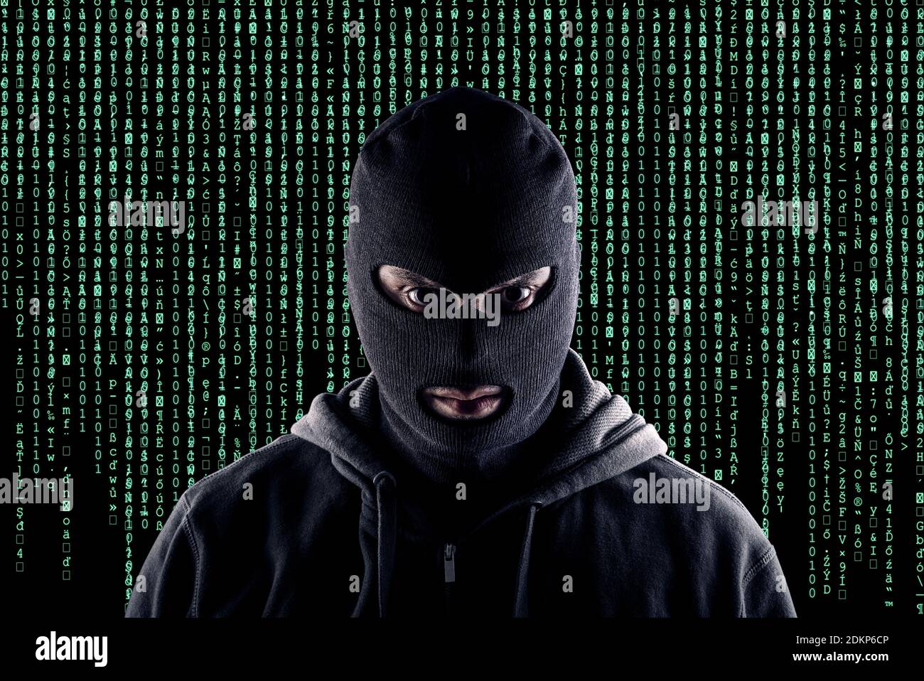 Masked cyber terrorist with black balaclava and hoodie in the dark Stock Photo