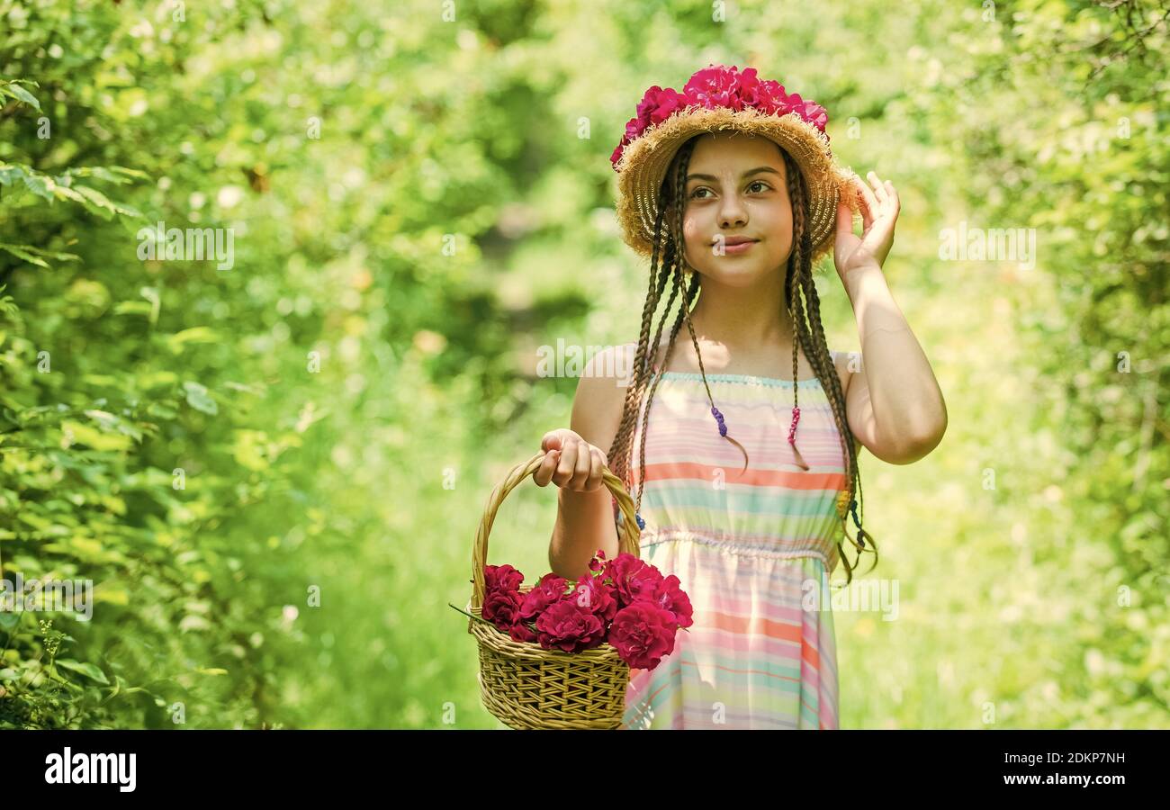 Joyful day. Hairstyle of nature. mothers day. happy womens day. Portrait of small kid with flowers. love and beauty. stunning girl with bouquet flowers of roses. happy child in straw hat Stock Joyful day. Hairstyle of nature. mothers day. happy womens day. Portrait of small kid with flowers. love and beauty. stunning girl with bouquet flowers of roses. happy child in straw hat Stock