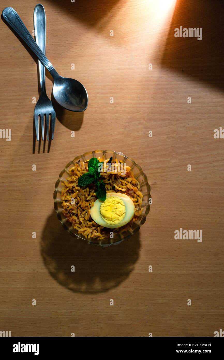 Tasty homemade egg biriyani in a bowl on the wooden table Stock Photo