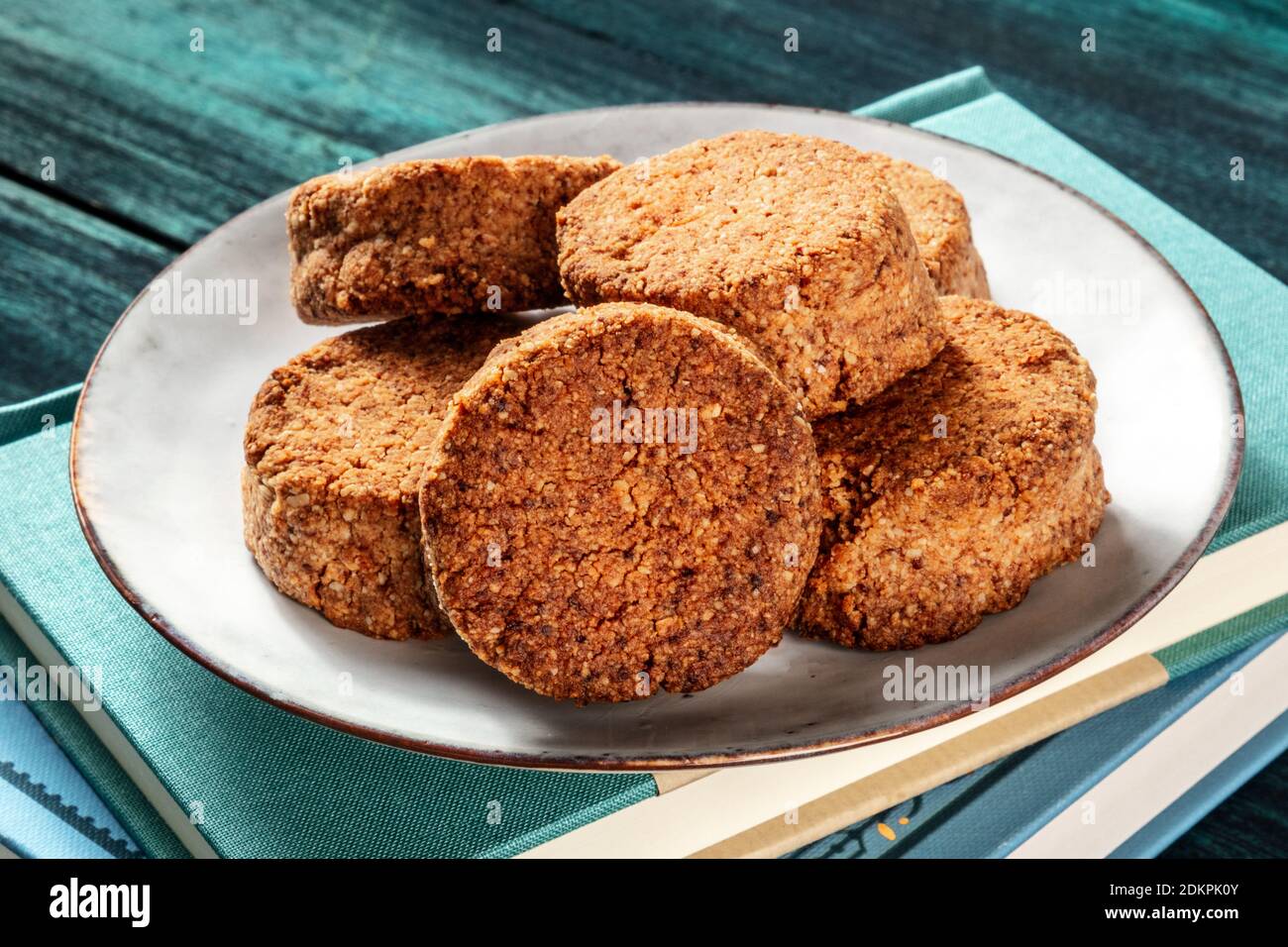Cookies and reading. A plate of homemade digestive biscuits on a stack of books Stock Photo