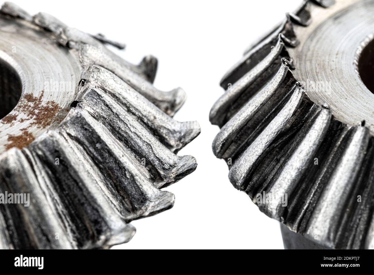 Macro shot of a two damaged bevel gears with beveled teeth, isolated on