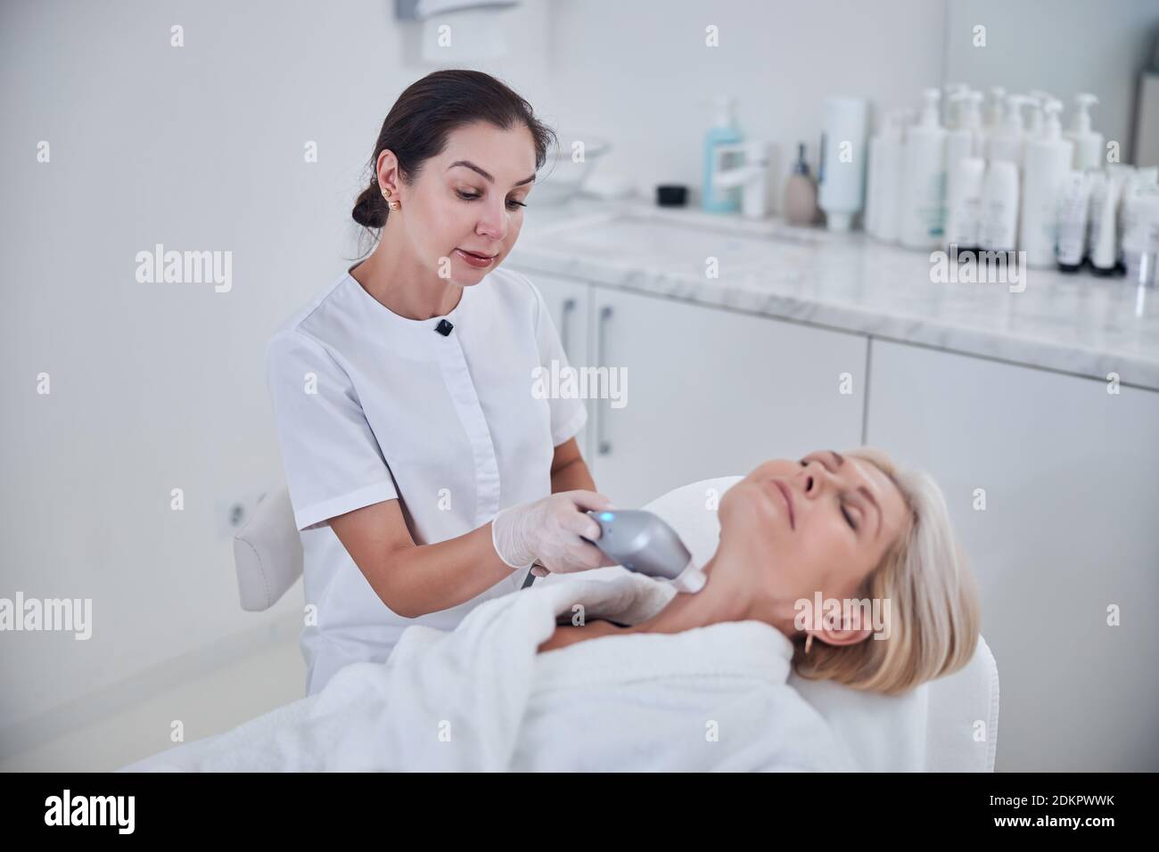 Female dermatologist using new special cosmetology device for skin care