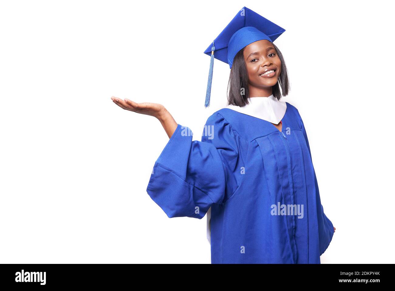 African-American beautiful woman in a blue robe and hat, on a white isolated background smiles and shows something Stock Photo