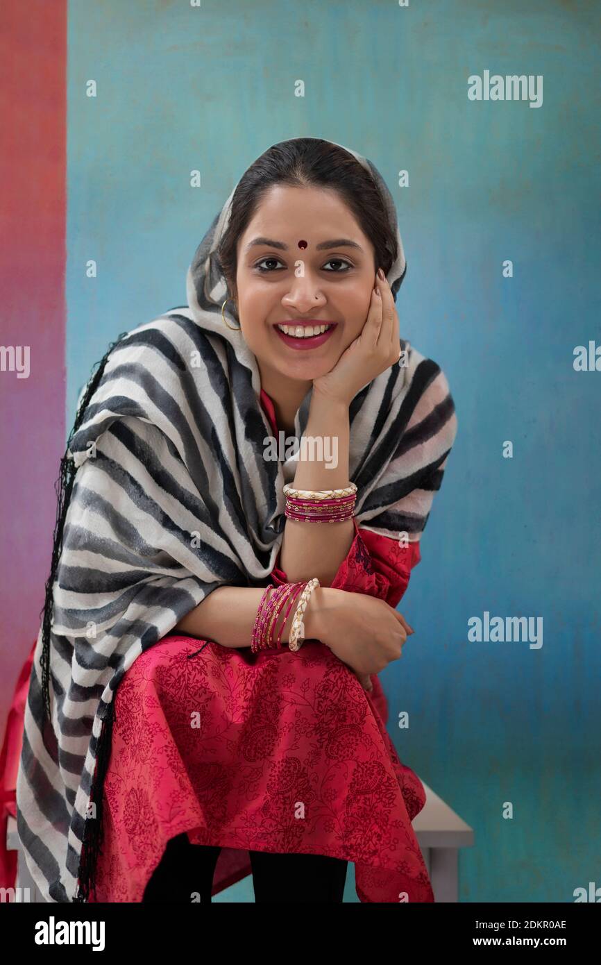A YOUNG WOMAN SITTING AND SMILING AT CAMERA Stock Photo - Alamy