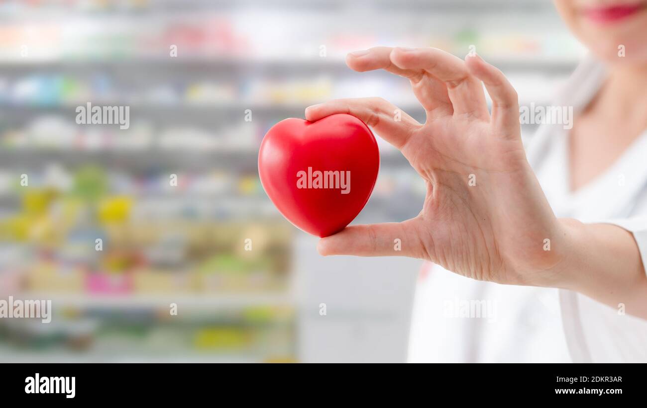 Doctor holding a red heart at hospital office. Medical health care and ...