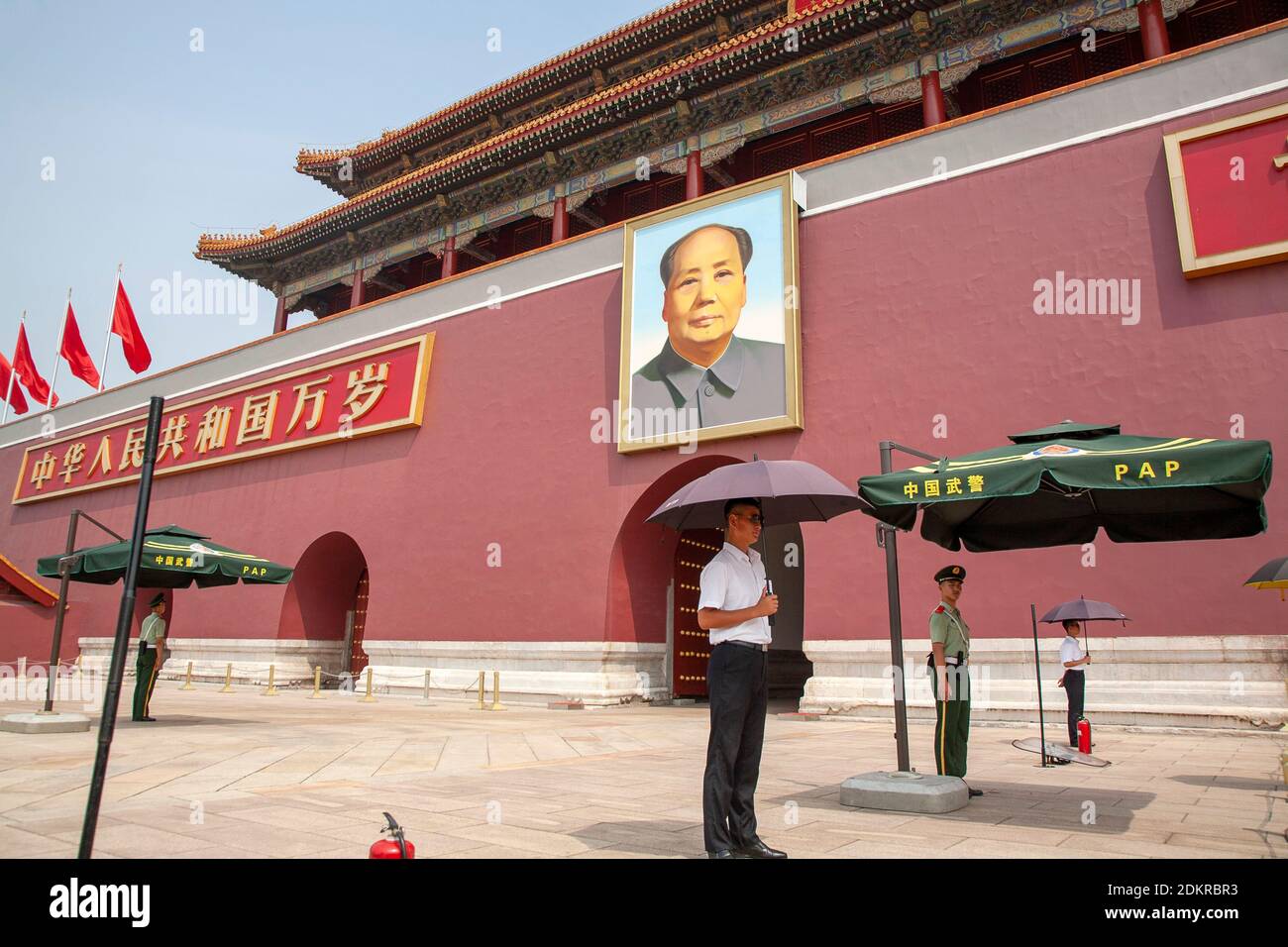 Tiananmen Gate of Heavenly Peace with portrait of Chairman Mao Zedong and Chinese Police guard under umbrella in Beijing Stock Photo
