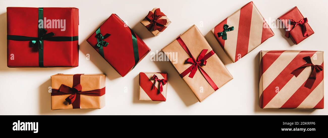 Flat-lay of festive craft gift boxes in wrapping paper decorated with green  and red ribbon bows over plain white background, top view, horizontal  composition. Christmas boxing day concept Stock Photo - Alamy