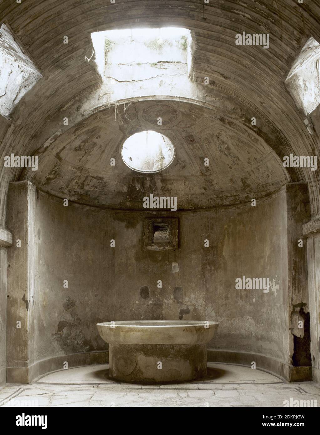 Italy, Pompeii. The Forum thermal baths. Public baths, edificated immediately after the founding of the colony (after 80 BC). They were subdivided into men’s and women’s section. Room of the 'calidarium' with its hot water bat. Basin which was filled with cold water so that bathers could cool off. Stock Photo