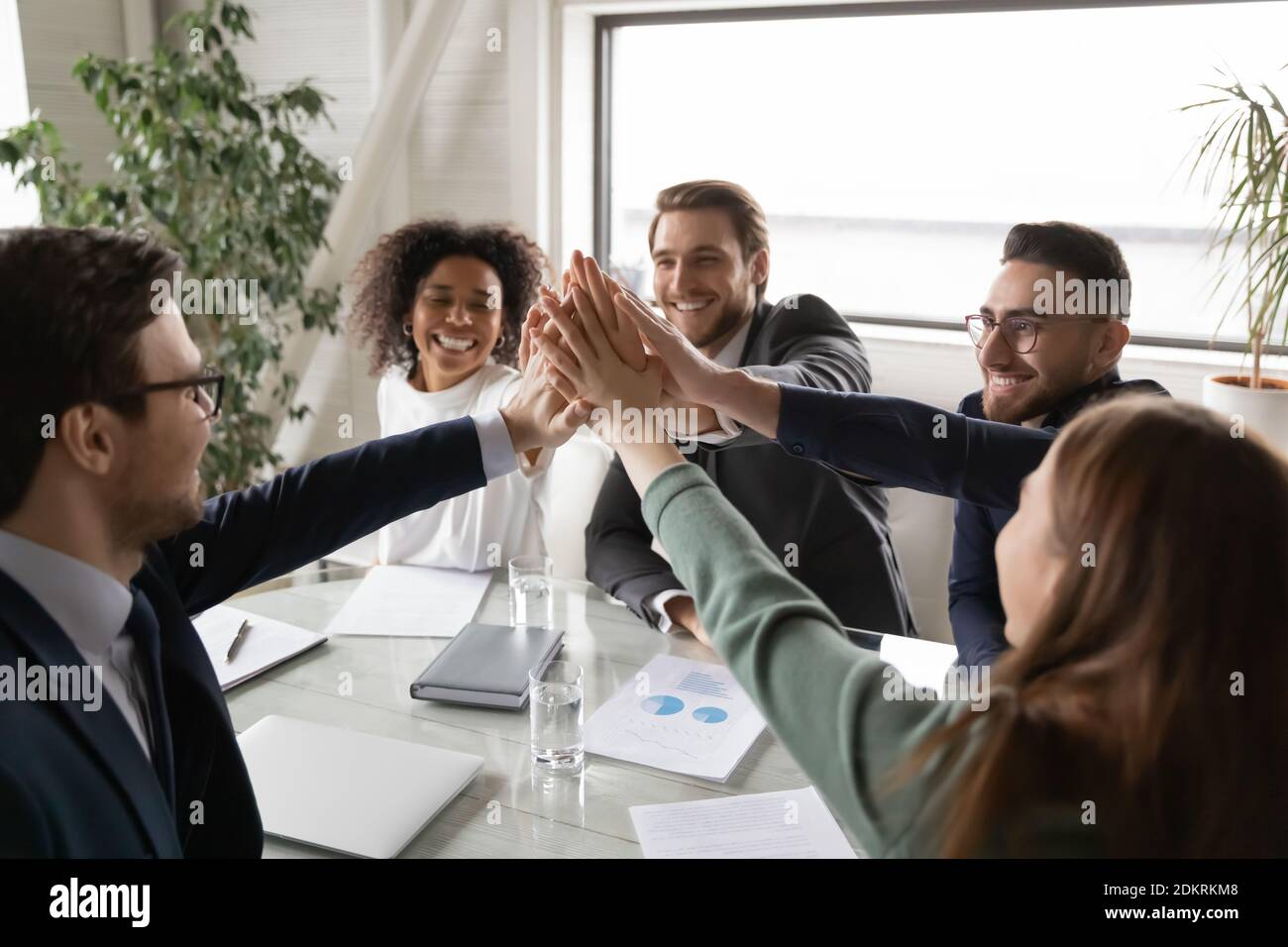 Excited diverse colleagues give high five at meeting Stock Photo - Alamy