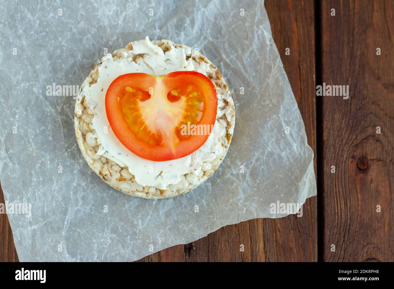 rice bread with cottage cheese and tomato on a wooden background.The view from the top. Stock Photo