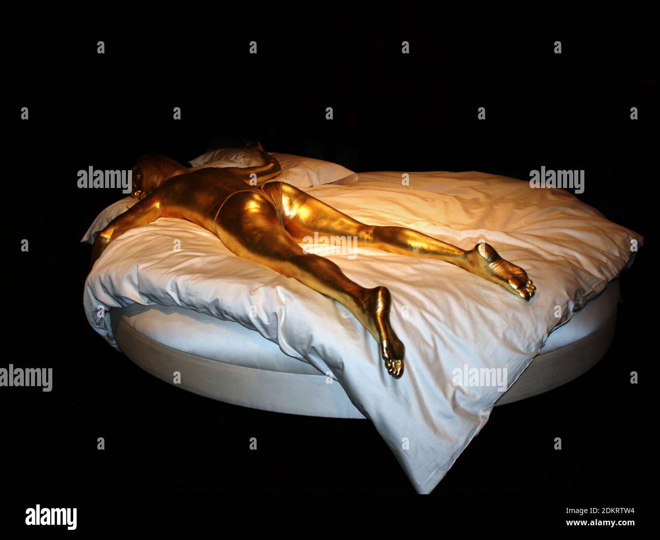 Display from Designing 007: 50 Years of Bond Style exhibition at London's Barbican A replica of Goldfinger's Shirley Eaton lies dead on a crumpled bed Stock Photo