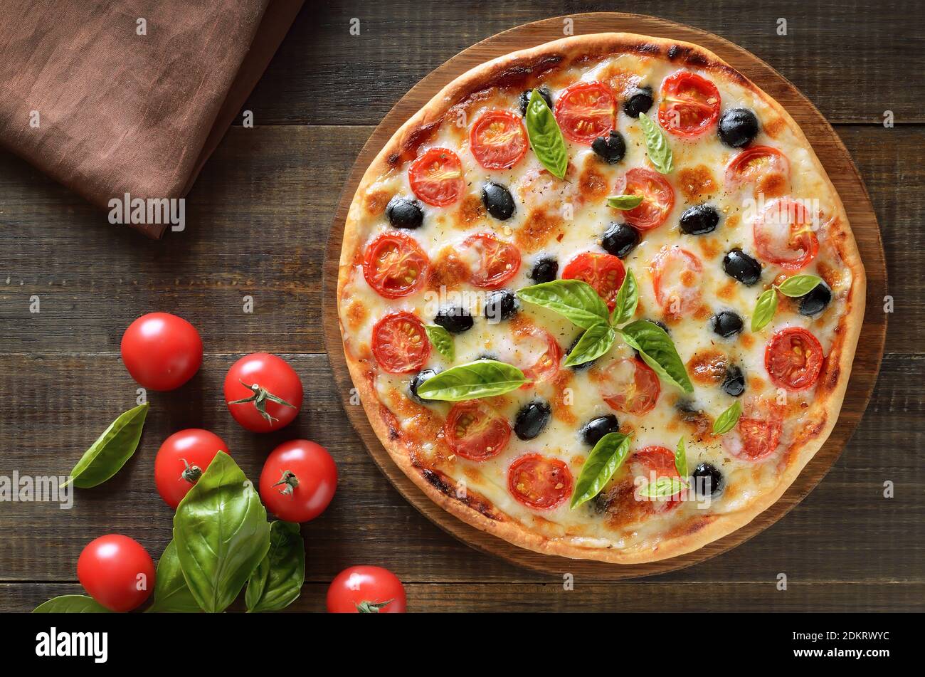 Homemade pizza with tomato and olives on wooden background. Top view, flat lay Stock Photo